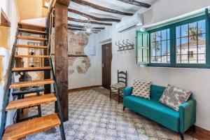 un salon avec un canapé bleu et un escalier dans l'établissement Ruralya Alojamientos Granada Constitución Square, à Grenade