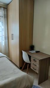 a bedroom with a desk and a bed next to a bed at MollyAnne studio in Nairobi