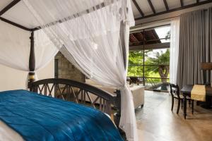 a bedroom with a bed with a canopy and a window at Ayugiri Ayurveda Wellness Resort Sigiriya in Sigiriya +103 photos