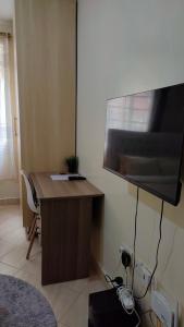 a room with a desk with a large flat screen tv at MollyAnne studio in Nairobi
