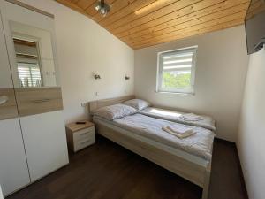 a small bedroom with a bed and a window at Przystań Ogrodowa Mikołajki in Mikołajki