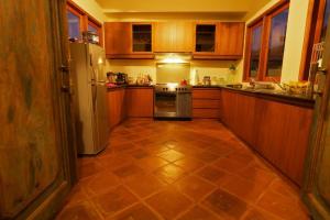 a kitchen with wooden cabinets and a stainless steel refrigerator at The Kampung in Amed