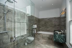 
a bathroom with a shower, toilet and tub at Mangapapa Hotel in Havelock North
