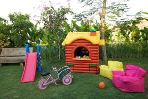 un juego con una casa de juguetes y un parque infantil en The Kampung, en Amed