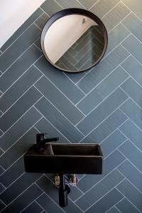 une salle de bain avec un lavabo noir et un miroir dans l'établissement Villa Baltica Premium, à Niechorze 38 autres photos