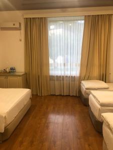 a hotel room with two beds and a window at Wald Hotel Lagodekhi in Lagodekhi