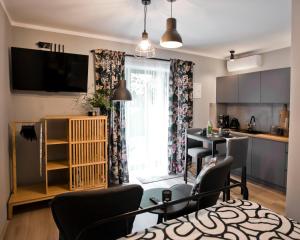 a kitchen and living room with a table and chairs at Balaton Apartamenty in Trzebinia