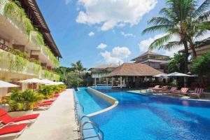 a pool at a resort with chairs and umbrellas at Blu-Zea Resort by Double-Six in Seminyak