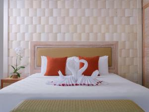 a bed with two white swans on it at Blu-Zea Resort by Double-Six in Seminyak