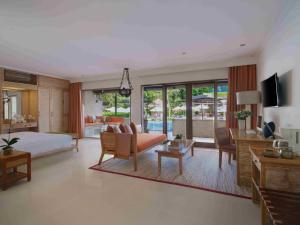 a bedroom with a bed and a living room at Blu-Zea Resort by Double-Six in Seminyak