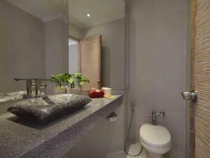 a bathroom with a toilet and a sink and a mirror at Blu-Zea Resort by Double-Six in Seminyak