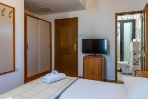 1 Schlafzimmer mit einem Bett und einem TV sowie einem TV mit audiovisuellen Kriterien in der Unterkunft Villa Residence Ičići in Ičići