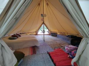 a tent with a bunch of beds in it at Käkiniitty Glamping Cuckoo Camp in Tammela