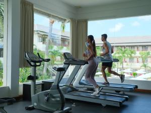 a man and woman running on a treadmill in a gym at Blu-Zea Resort by Double-Six in Seminyak