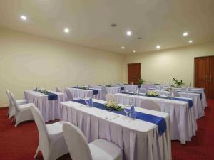 a room full of tables and chairs with white table cloths at Blu-Zea Resort by Double-Six in Seminyak