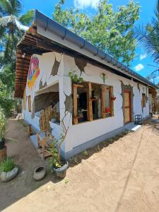 a small house with a painting on the side of it at C U Hostel in Trincomalee