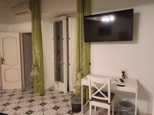a room with a desk and a television on the wall at Relais Zio Vincenzo Casa Positano in Positano