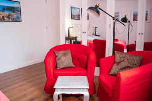 a living room with red chairs and a table at CASA RURAL GA7COLORES only adult in Montaña Blanca