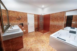 a bathroom with a tub and a sink and a shower at CASA RURAL GA7COLORES only adult in Montaña Blanca