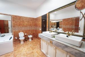 a bathroom with three sinks and a toilet and a large mirror at CASA RURAL GA7COLORES only adult in Montaña Blanca