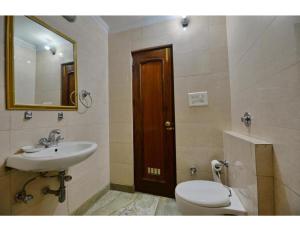 a bathroom with a sink and a toilet and a mirror at Hotel GK President, Chandigarh in Chandīgarh