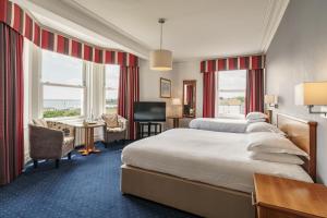 a hotel room with a large bed and a television at The Palace Hotel in Paignton