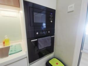 a microwave oven in a kitchen with a towel at Setia Alam 58 by Manhattan Group in Setia Alam