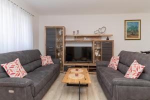 a living room with two couches and a television at Villa GRACO in Imotski