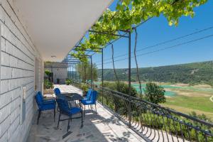a balcony with blue chairs and a table with a view at Villa GRACO in Imotski