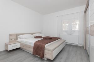 a white bedroom with a bed and a window at Villa GRACO in Imotski +19 photos