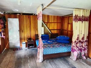 1 dormitorio con 1 cama con sábanas y cortinas azules en Rammang Rammang village, en Baloci