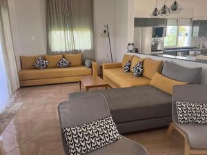 ein Wohnzimmer mit 2 Sofas und einer Küche in der Unterkunft Villa campagne bouznika in Bouznika