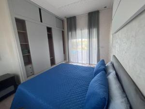 ein Schlafzimmer mit einem blauen Bett und einem Fenster in der Unterkunft Villa campagne bouznika in Bouznika