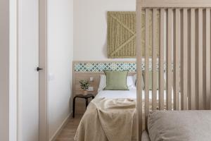 una camera da letto con una culla con un cuscino verde di Líbere Córdoba Tendillas a Cordoba
