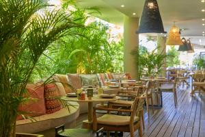 a restaurant with tables and chairs and plants at Suite Hotel Eden Mar - PortoBay in Funchal