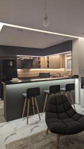 a kitchen with a bar with two stools and a counter at New Cairo Serviced Apartment in Cairo +2 photos