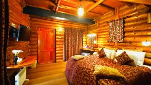 a bedroom with a bed in a room with wooden walls at Queenswood Cottage in Nuwara Eliya