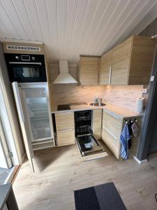 a small kitchen with wooden cabinets and a stove at Hunnebostrand, Ramsviklandet, Smögen, Bohuslän, Vestkusten in Hunnebostrand