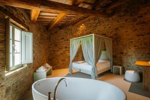 阿西西Agriturismo Molinella的一间带浴缸的浴室和一张位于客房内的床