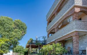 a brick building with a balcony and trees at Apartment M- Panoramic View in Mugeba