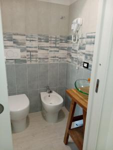 a bathroom with a toilet and a sink at Neruda Chic House Sant'Angelo in Sant'Angelo D'Ischia +44 photos