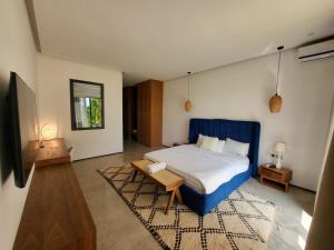 a bedroom with a blue bed and a rug at Villa Marrakech in Oubadine +40 photos