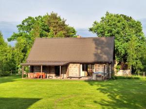a log cabin with a large grassy yard at Palmas in Jūrkalne