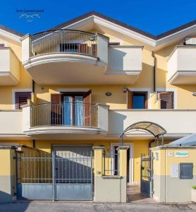 a yellow building with a balcony and a gate at Villa Vespucci - appartamento di 170mq in Montesilvano