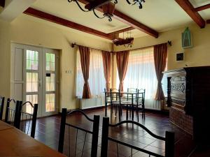 a dining room with chairs and a table and a fireplace at Casa Zmeilor in Tăşnad