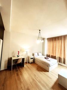 雅典Minimalistic Studio with Acropolis View Shared Roof Top的一间卧室，里面有一张床、一张桌子和一扇窗户