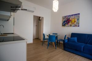 a living room with a blue couch and a table at Verde oleandro & Blu mare in Marina di Ascea