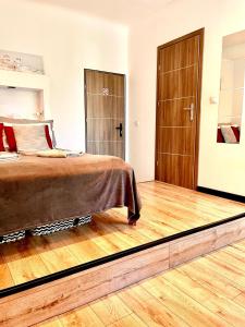 a bedroom with a bed and a wooden floor at Nice 1Room Condo WarszawaCenter in Warsaw