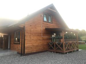 a large wooden cabin with a porch and windows at Dom Wakacyjny Bogaczewo in Bogaczewo