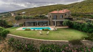 a house with a large yard with a swimming pool at Villa Oliva - Majestic Views in Andros